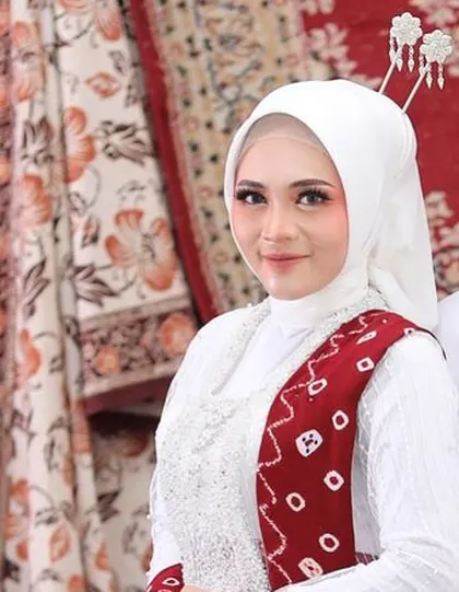 Putri berhijab putih dengan selempang batik merah