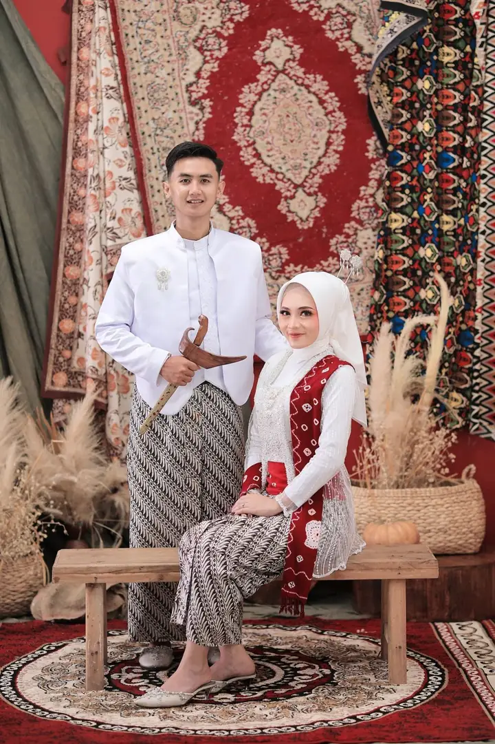 Willy dan Putri berfoto dengan busana putih dan batik parang